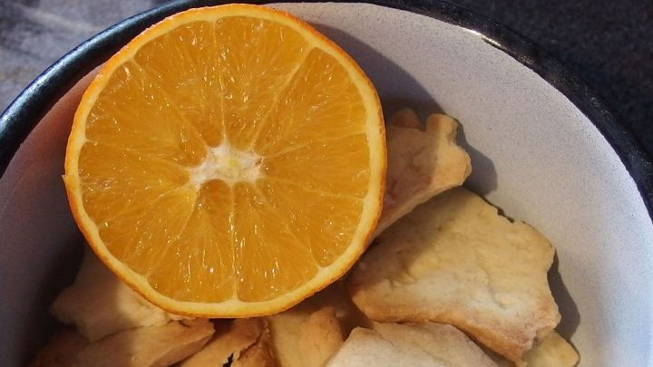 In einer Sch&uuml;ssel liegen trockene Pl&auml;tzchen mit einer frisch aufgeschnittenen Orange, die zur Wiederherstellung der Weichheit dient.