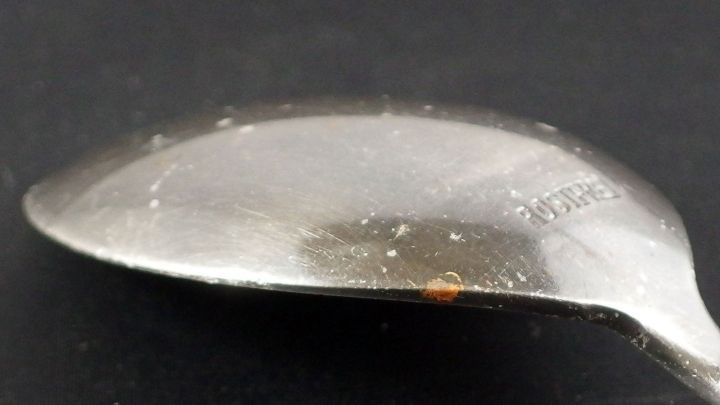 Eine gl&auml;nzende L&ouml;ffeloberfl&auml;che zeigt Flugrost, der auf Verunreinigungen in der Sp&uuml;lmaschine hindeutet.