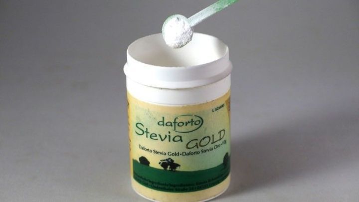 Ein Dosierl&ouml;ffel steckt in einem Steviapulverbeh&auml;lter, der auf einem neutralen Hintergrund steht, ideal zum leichten Dosieren.