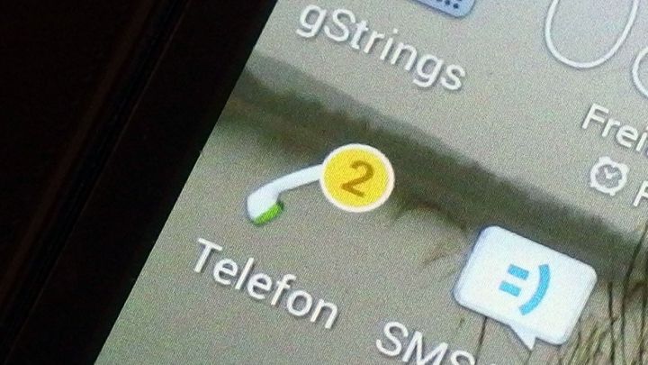 Ein Symbol zeigt zwei verpasste Anrufe auf einem Smartphone. Die App "Telefon" ist im Vordergrund des Displays sichtbar.