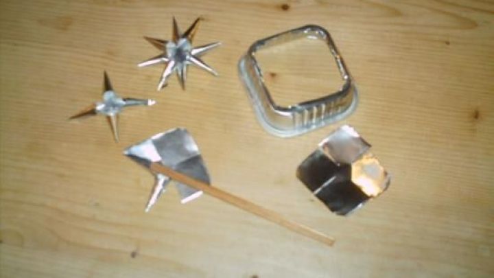 Sterne aus Katzenfuttersch&auml;lchen liegen auf einem Holztisch, w&auml;hrend eine verspielt gestaltete Szenerie entsteht.