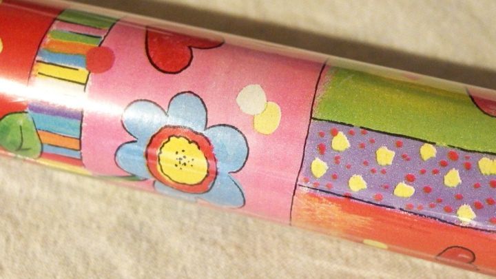 Buntes Geschenkpapier liegt auf einer wei&szlig;en Fl&auml;che, bereit zum Ausschneiden f&uuml;r kreative Verpackungen.