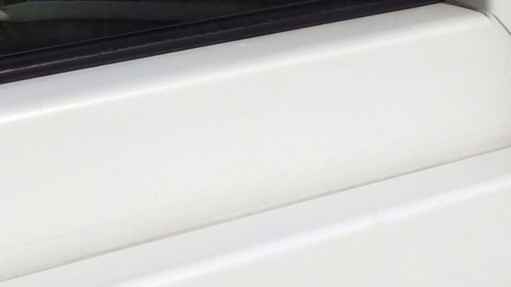 Ein wei&szlig;er Fensterrahmen wird mit einem Glaskeramikfeldreiniger gereinigt, um Schmutz und Flecken zu entfernen.