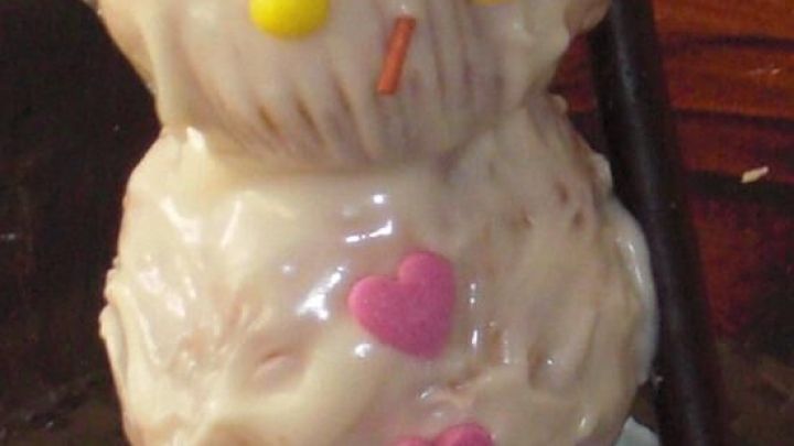 Ein Schneemann aus Schokolade steht auf einem Tisch, dekoriert mit bunten S&uuml;&szlig;igkeiten und einer Kappe aus Schokolade.