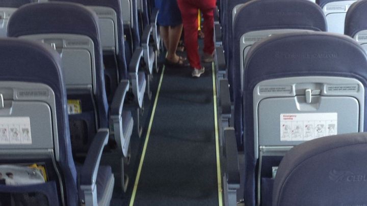 Reihen von Flugzeugsitzen mit Stewardessen, die w&auml;hrend des Fluges durch den Gang gehen, sorgen f&uuml;r Komfort ohne Druck.