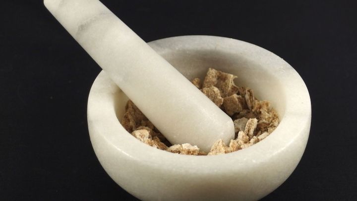 Ein M&ouml;rser aus hellem Material zerreibt Zutaten in einer Schale, um Gew&uuml;rze f&uuml;r verschiedene Panierungen vorzubereiten.