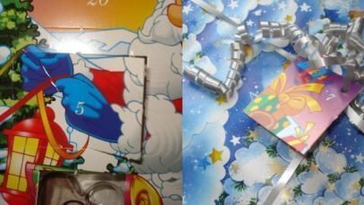 Bunte Geschenkanh&auml;nger aus einem Schokoladen-Adventskalender liegen umgeben von weihnachtlicher Dekoration auf einem Tisch.