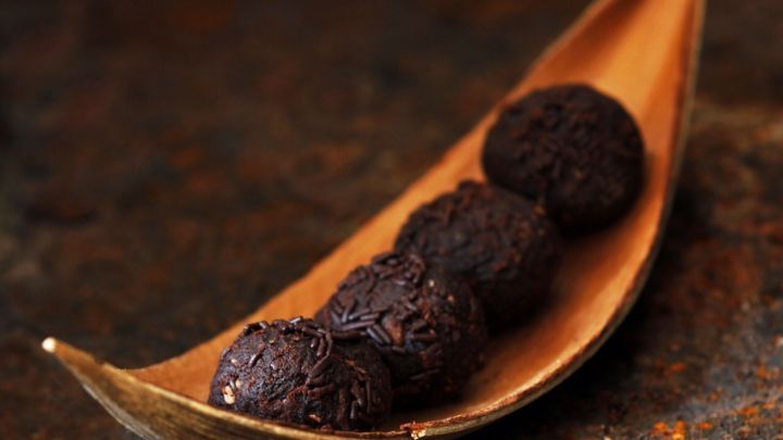 Schokokugeln liegen in einer schmalen, gebogenen Schale auf einem rustikalen Hintergrund, ready to be genossen.