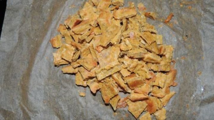 Ein Haufen Leberwurst-Chips liegt auf braunem Backpapier, bereit f&uuml;r den Hundegenuss.