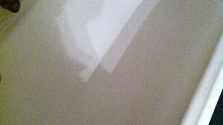 Eine wei&szlig;e Badewanne steht in einem Badezimmer, sauber und leer, auf einem hellen, gefliesten Boden.