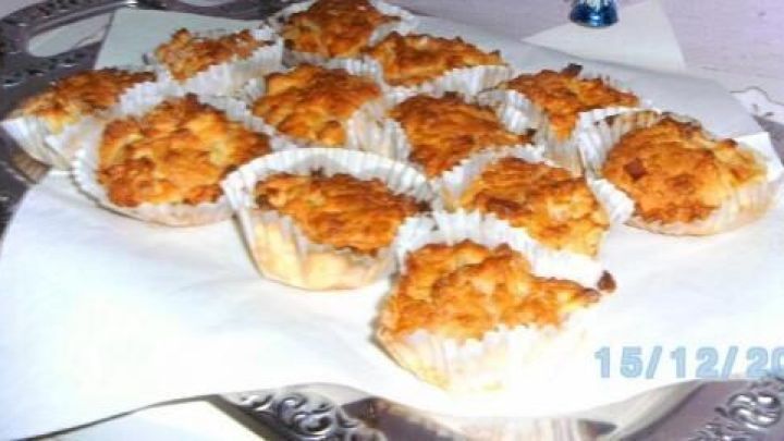 Leckere Muffins mit einer goldbraunen Kruste aus Mandeln, kunstvoll auf einer Servierplatte angeordnet.