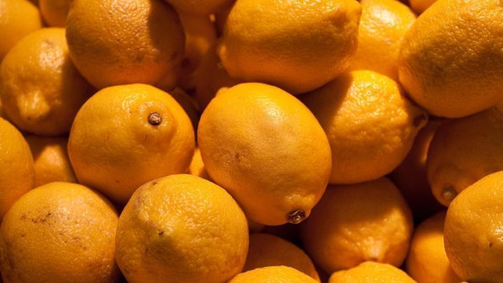 Zitronen liegen dicht aneinander, leuchten gelb im Licht und bilden ein frisches, enges Muster.