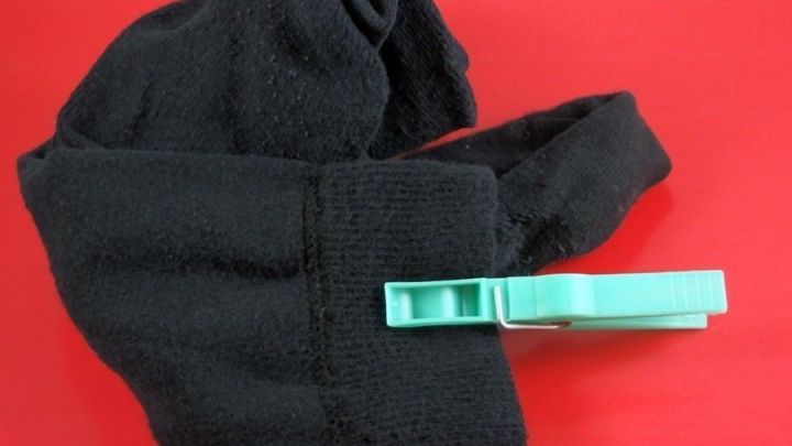 Ein schwarzer Socken wird mit einer gr&uuml;nen Klammer fixiert, um das Sortieren von Socken zu erleichtern.