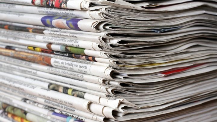 Staple Zeitungen liegen gestapelt, was auf das Interesse an praktischen Tipps gegen Zugluft beim Fenster hindeutet.