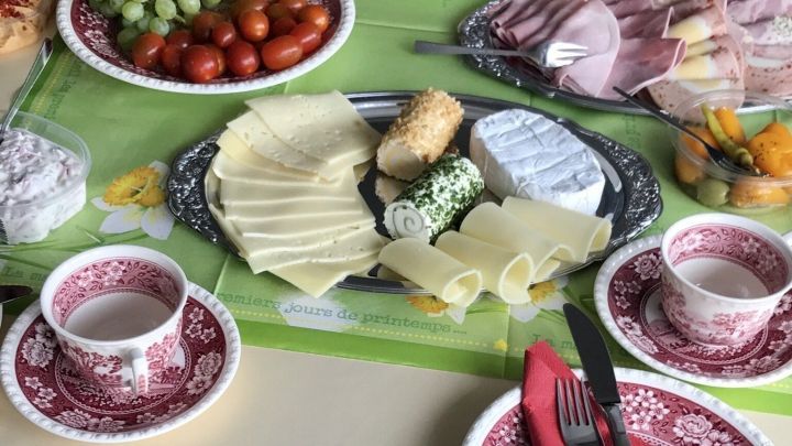Eine festlich gedeckte Tafel zeigt eine "Bergische Kaffeetafel" mit Aufschnitt, K&auml;se, Obst und Tassen in einem einladenden Raum.