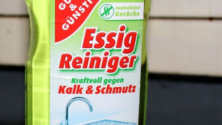 Eine Flasche Essigreinigung steht auf einer Oberfl&auml;che und wirkt gegen Urinflecken in Tierk&auml;figen.