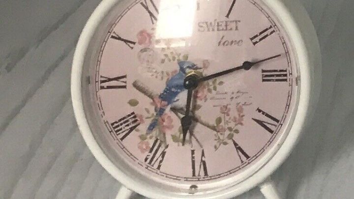 Eine wei&szlig;e Standuhr zeigt mit r&ouml;mischen Ziffern die Zeit, verziert mit Blumen und einem blauen Vogel. Text: "SWEET love".