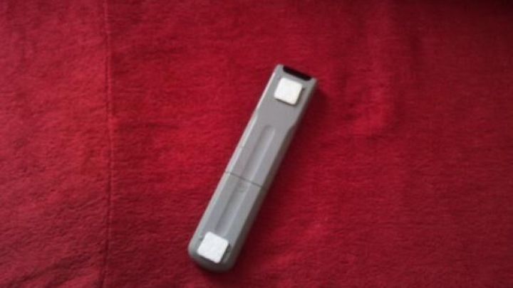 Eine Fernbedienung liegt auf einem roten Tuch, was darauf hindeutet, dass sie m&ouml;glicherweise Kratzer auf einem Tisch hinterlassen k&ouml;nnte.