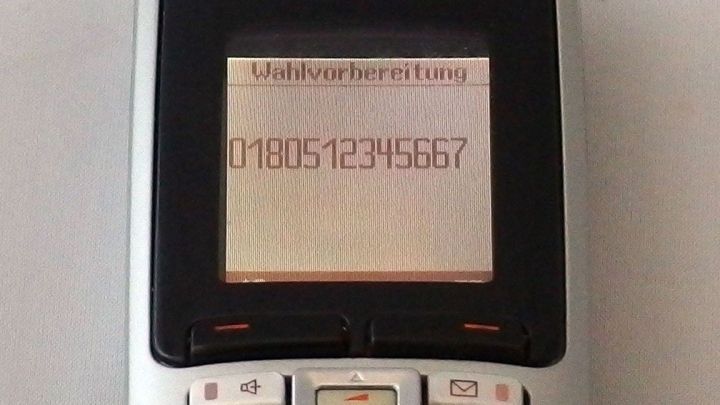 Telefondisplay zeigt "Wahlvorbereitung" und die Nummer "018051234567", was einen Anruf bei einer Service-Hotline vorbereitet.