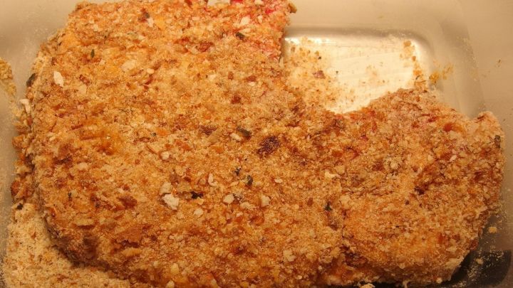 Paniertes Kotelett liegt goldbraun in einer Auflaufform, umgeben von einer knusprigen Kruste, bereit zum Servieren.