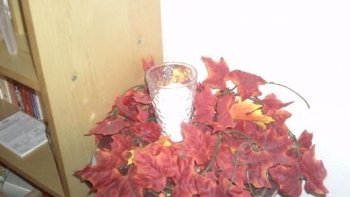 Ein Tisch dekoriert mit roten Bl&auml;ttern und einem Glas, das mit Salz gef&uuml;llt ist, schafft eine winterliche Atmosph&auml;re.