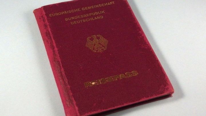 Ein rotes Passbuch liegt auf einer neutralen Oberfl&auml;che, bereit zum Scannen oder Fotografieren f&uuml;r wichtige Reisedokumente.