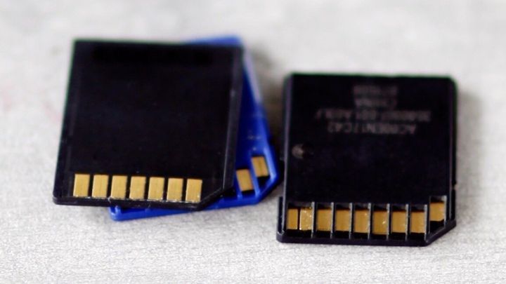 Speicherkarten liegen &uuml;bereinander auf einem grauen Untergrund, zeigen goldene Kontakte. Keine erkennbare Beschriftung.