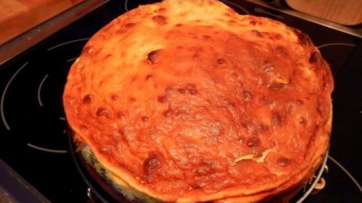 Ein frisch gebackener russischer Apfelkuchen steht auf einem Herd, golden gebr&auml;unt und appetitlich, im Zuhause.