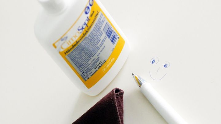 Ein Kugelschreiber liegt auf einem Lacktisch neben einer Flasche.

---