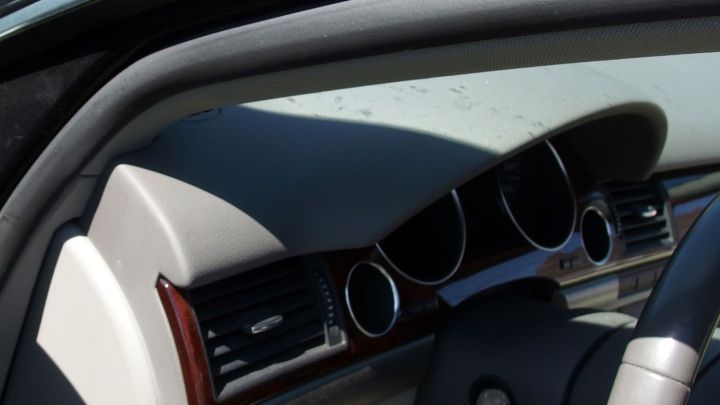 Der Innenraum eines Autos zeigt das Armaturenbrett mit L&uuml;ftungs&ouml;ffnungen, das von Sonne beleuchtet wird.