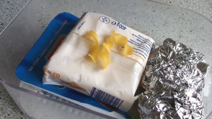 Eine Frischhaltedose enth&auml;lt ein St&uuml;ck Butter, Schalenreste und Aluminiumfolie, die zusammen Feuchtigkeit vermeiden sollen.