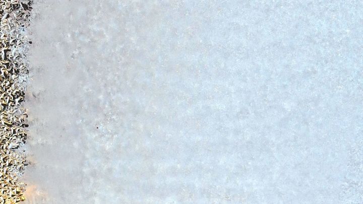 Eisige Autoscheiben sind sichtbar, w&auml;hrend das Innere eines Fahrzeugs erkennbar ist; kalte Temperaturen verursachen Vereisung.