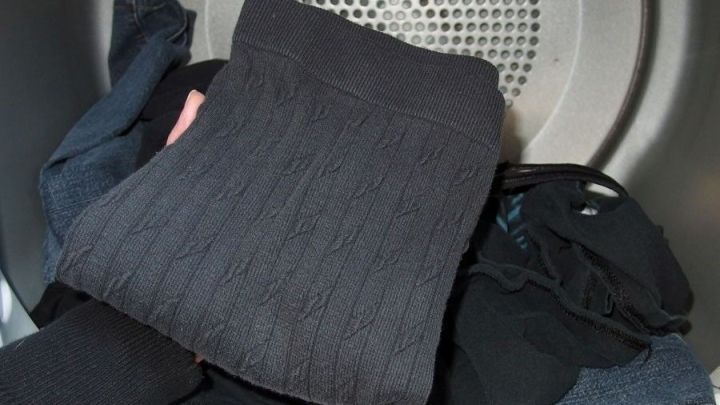 Eine Ansammlung von glatten, frisch gewaschenen Kleidungsst&uuml;cken liegt im W&auml;schetrockner und wartet auf die Entnahme.