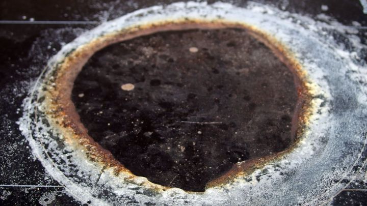 Ein stark verkrusteter Backofenboden zeigt eingebackene R&uuml;ckst&auml;nde, die dringend mit Backofenreiniger behandelt werden m&uuml;ssen.