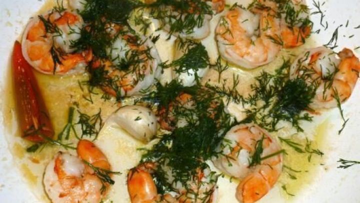 Garnelen werden in einer Pfanne mit Kr&auml;utern und Gew&uuml;rzen zubereitet, um ein schmackhaftes Gericht zu kreieren.