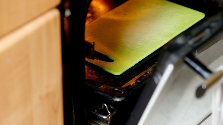Eine gew&ouml;lbte Schneidematte liegt in einem offenen Backofen, leicht erw&auml;rmt, um sie wieder glatt zu bekommen.