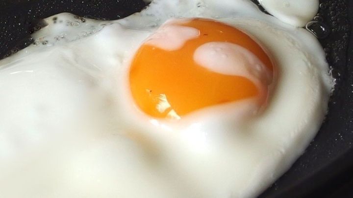 Ein Spiegelei br&auml;t in einer Pfanne, ohne einen braunen Rand zu zeigen, um ein perfektes Fr&uuml;hst&uuml;ck zu kreieren.