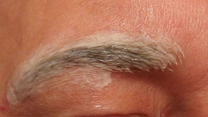 Ein Augenbraue wird mit einer Zupf-Creme behandelt, um das Zupfen so gut wie schmerzlos zu gestalten.