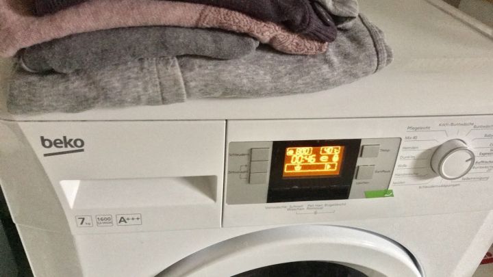 Auf einem wei&szlig;en W&auml;schetrockner liegen ordentlich gefaltete, saubere Handt&uuml;cher, die das B&uuml;geln &uuml;berfl&uuml;ssig machen.