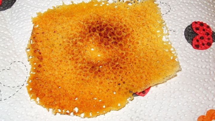 Ein K&auml;secracker liegt auf einem K&uuml;chenpapier, leicht goldbraun und knusprig, nach der Zubereitung in der Mikrowelle.