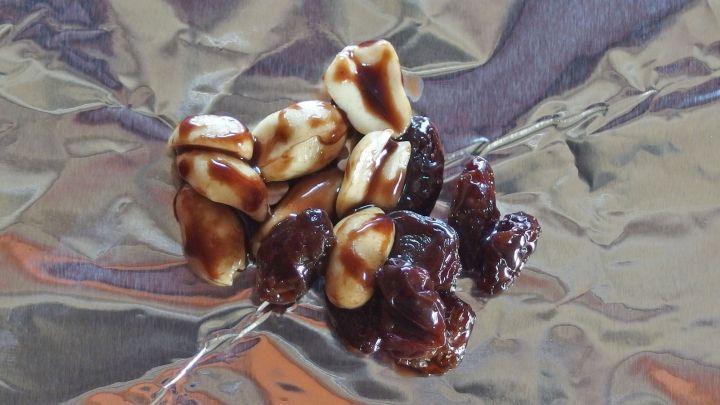 Schokorosinen liegen auf gl&auml;nzendem Aluminiumfolie, w&auml;hrend die s&uuml;&szlig;en Snacks darauf warten, genossen zu werden.