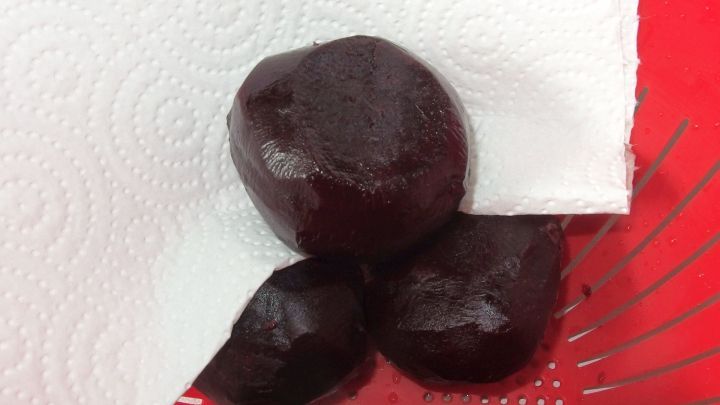 Gekochte Rote-Bete-Knollen liegen auf einem K&uuml;chenpapier in einer Sch&uuml;ssel, bereit zum Sch&auml;len und Zubereiten.