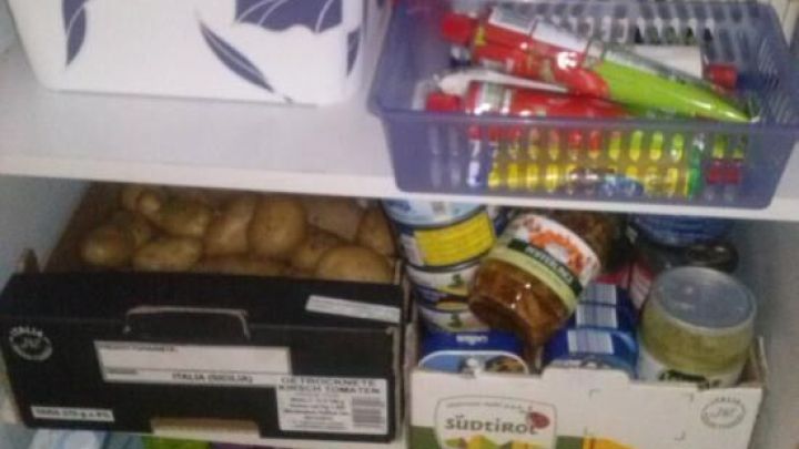 Kartons werden in einem K&uuml;chenschrank als Schublade genutzt, um Lebensmittel und Utensilien ordentlich zu lagern.