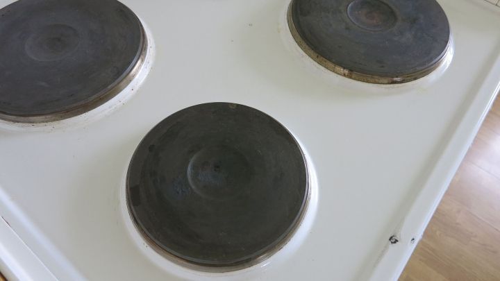 Schwarze Herdplatten auf einer wei&szlig;en Kochplatte, die sauber und gepflegt aussehen, bereit zum Kochen in einer modernen K&uuml;che.