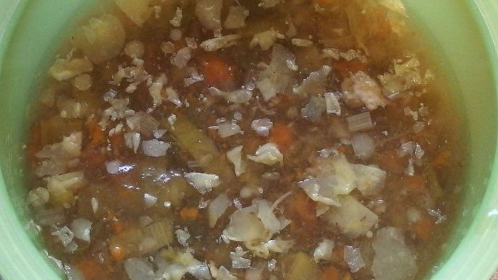 Ein Suppentopf enth&auml;lt eine br&auml;unliche Suppe mit St&uuml;ckchen von Gem&uuml;se und Fleisch, die sorgf&auml;ltig zubereitet wurde.