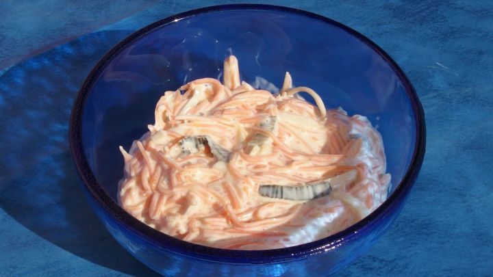 Ein blauer Sch&uuml;ssel enth&auml;lt einen cremigen Farmersalat, der auf einer glatten Oberfl&auml;che ansprechend angerichtet ist.