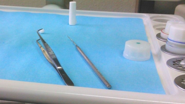 Zahnbehandlungsinstrumente liegen auf einem blauen Tuch, bereit f&uuml;r eine Behandlung, m&ouml;glicherweise zur Linderung von Tinnitus.