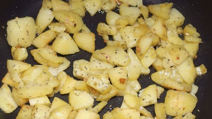 Knusprige Knoblauch-Bratkart&ouml;ffelchen braten in einer Pfanne, goldbraun gew&uuml;rzt und appetitlich angerichtet.