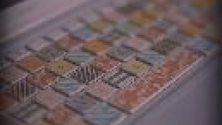 Eine bunte Tastatur steht auf einem Tisch; Tasten sind individuell gestaltet mit Pastellfarben und Mustern im Fokus auf Design.