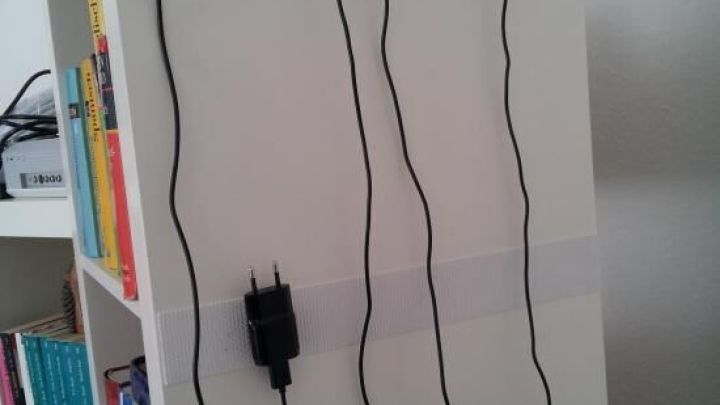 Ladekabel sind ordentlich an einer wei&szlig;en Wandhalterung befestigt, um Kabelsalat zu vermeiden und Ordnung zu schaffen.